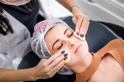 Beautician cleanses skin woman with sponge in spa beauty salon. cosmetology treatment skincare face