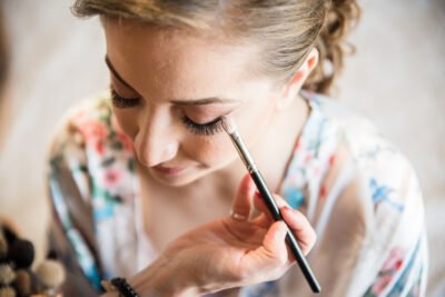 Makeup artist preparing bride before the wedding.